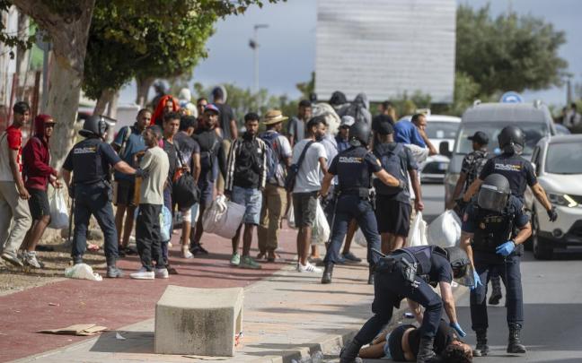 La Policía Nacional atiende a un migrante en Ceuta.