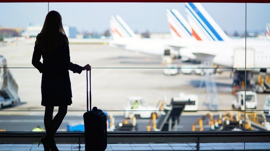 Una mujer espera para embarcar en su vuelo.
