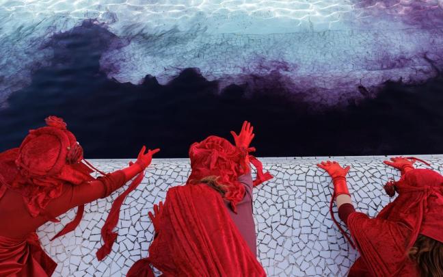 Un grupo de activistas tiñe un estanque de la Ciudad de las Artes y las Ciencias de València.