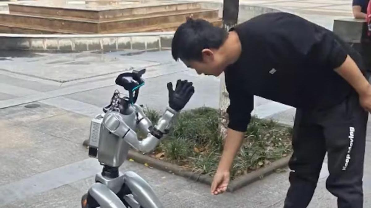 Un hombre dona dinero a un robot humanoide que pide limosna en China