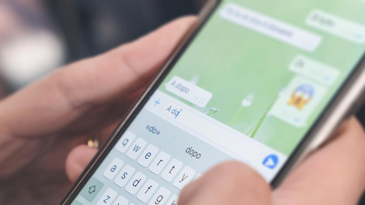 Una mujer escribe y manda gifs por WhatsApp.