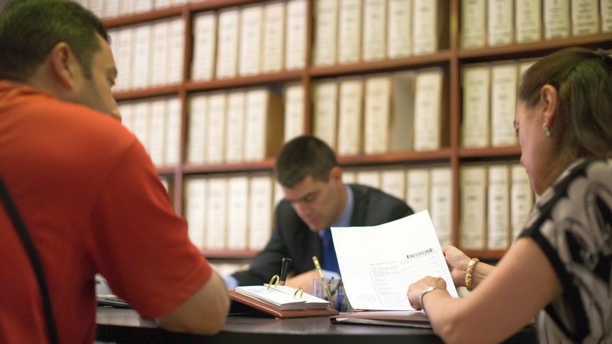 Personas comprobando documentos en una notaría