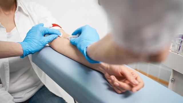 Un sanitario toma una muestra de sangre a una paciente.