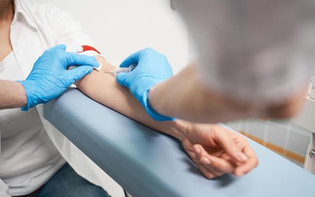 Un sanitario toma una muestra de sangre a una paciente.