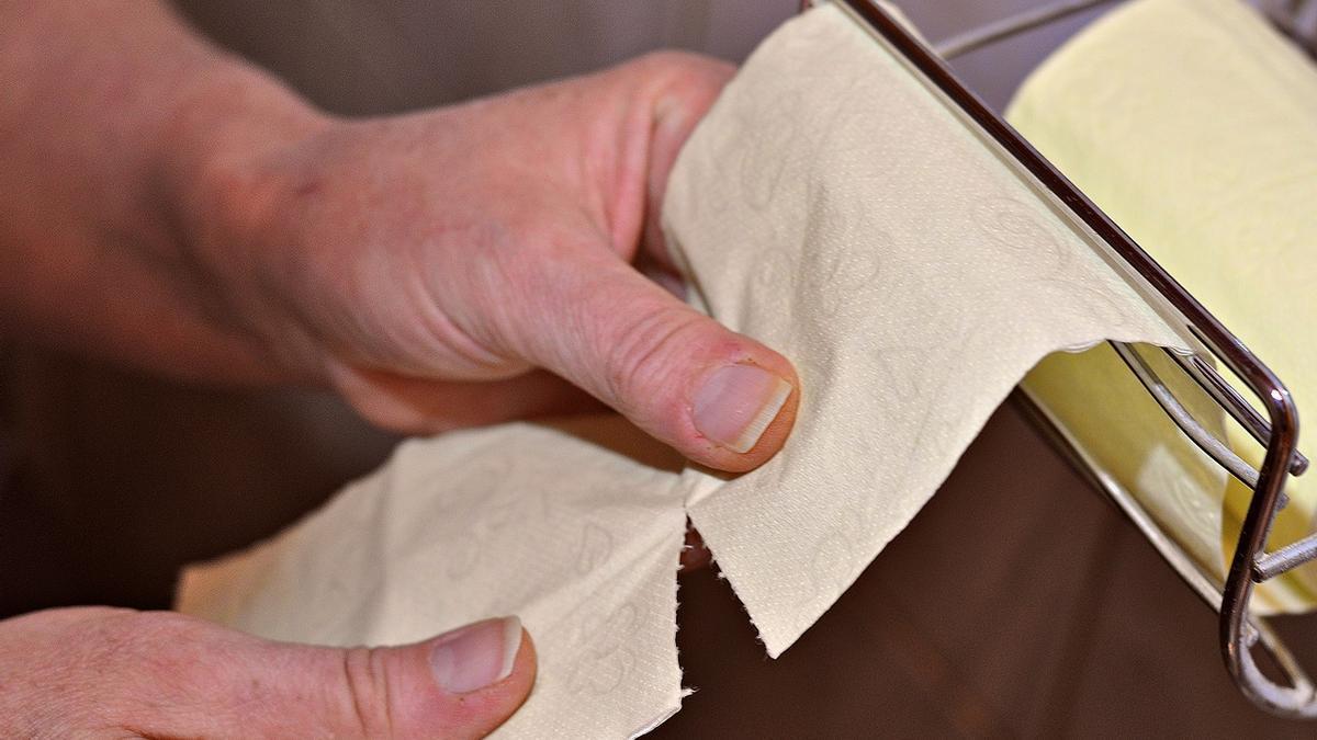 Una persona coge papel higiénico.