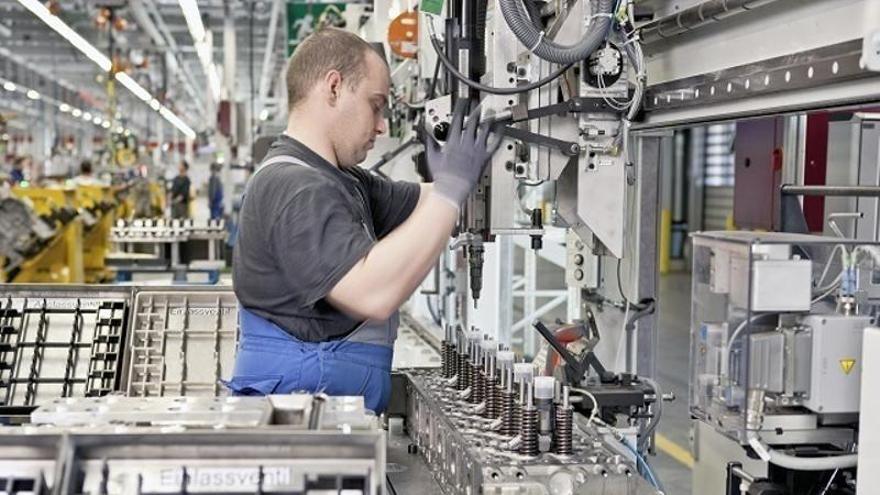 Un operario trabaja en una fábrica de motores de vehículos.