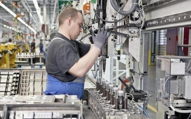 Un operario trabaja en una fábrica de motores de vehículos.