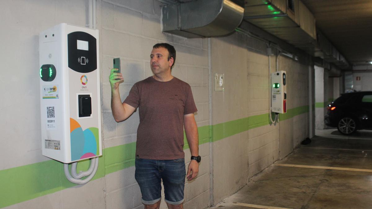 El edil Xabier Igartua mostrando el funcionamiento de los cargadores en el parking de Zubikoa, donde se han habilitado cuatro plazas; el mismo número que en Kalegoiena.