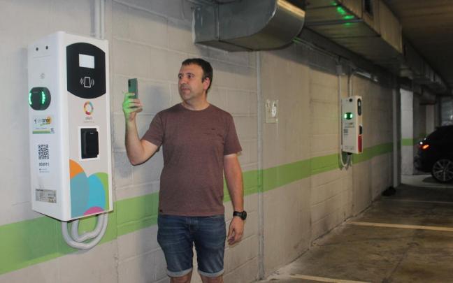 El edil Xabier Igartua mostrando el funcionamiento de los cargadores en el parking de Zubikoa, donde se han habilitado cuatro plazas; el mismo número que en Kalegoiena.