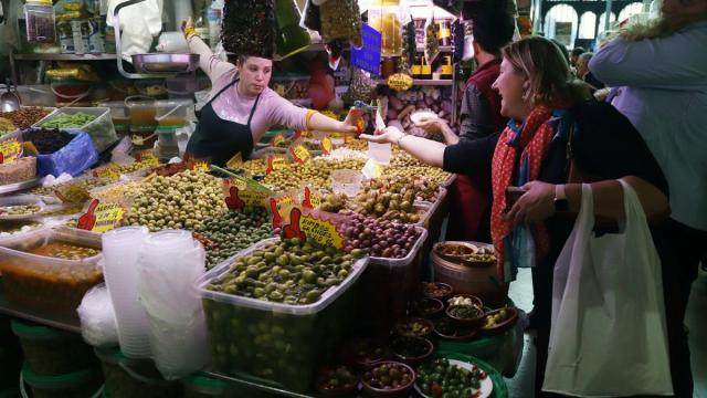 Una mujer vendiendo encurtidos en el del mercado de abastos.