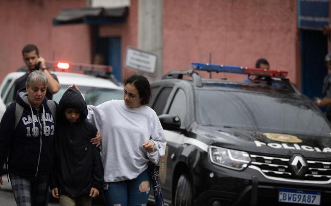 Familiares acompañan la salida de un estudiante del colegio público donde ha ocurrido el ataque.