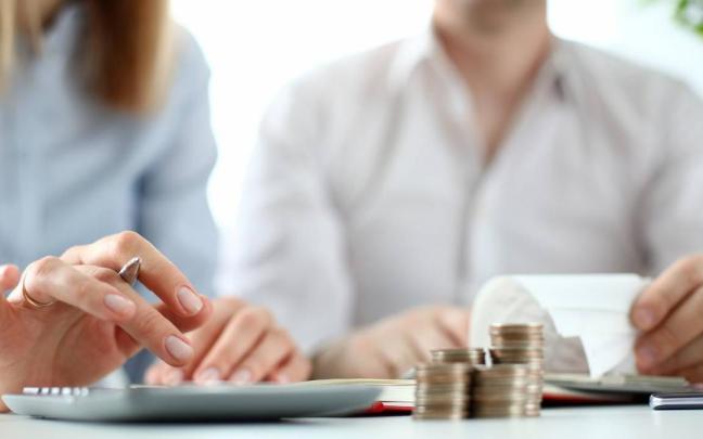 Dos personas realizan cálculos para conseguir un aval bancario
