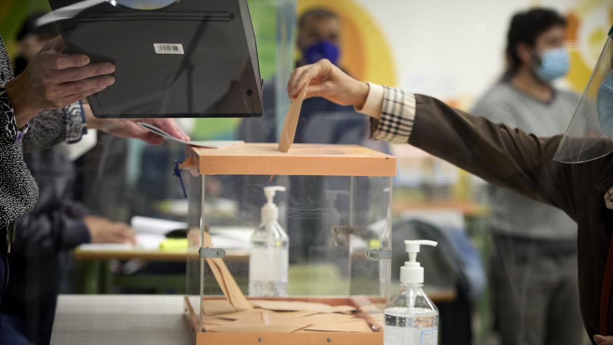 Una mujer vota en una mesa electoral.