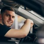 Un hombre sentado al volante de un coche de segunda mano.