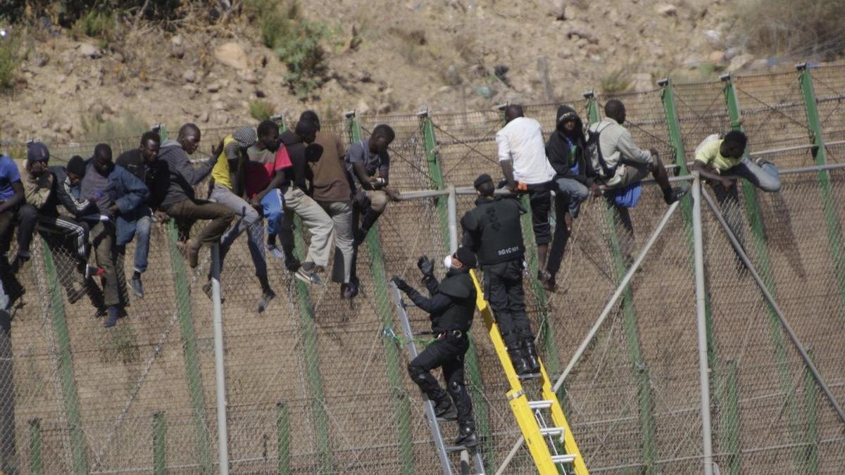 Inmigrantes encaramados a la valla de Melilla el 13 de agosto de 2014.