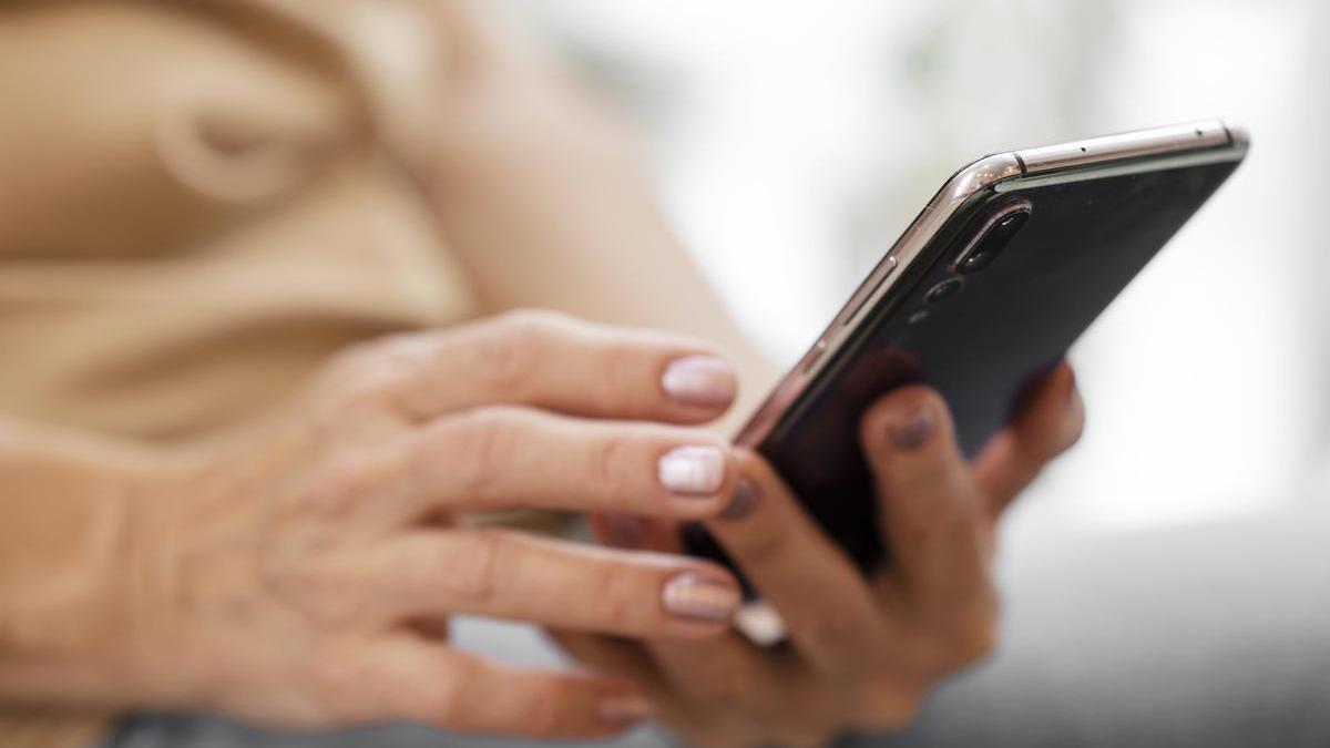 Mujer revisa su teléfono móvil