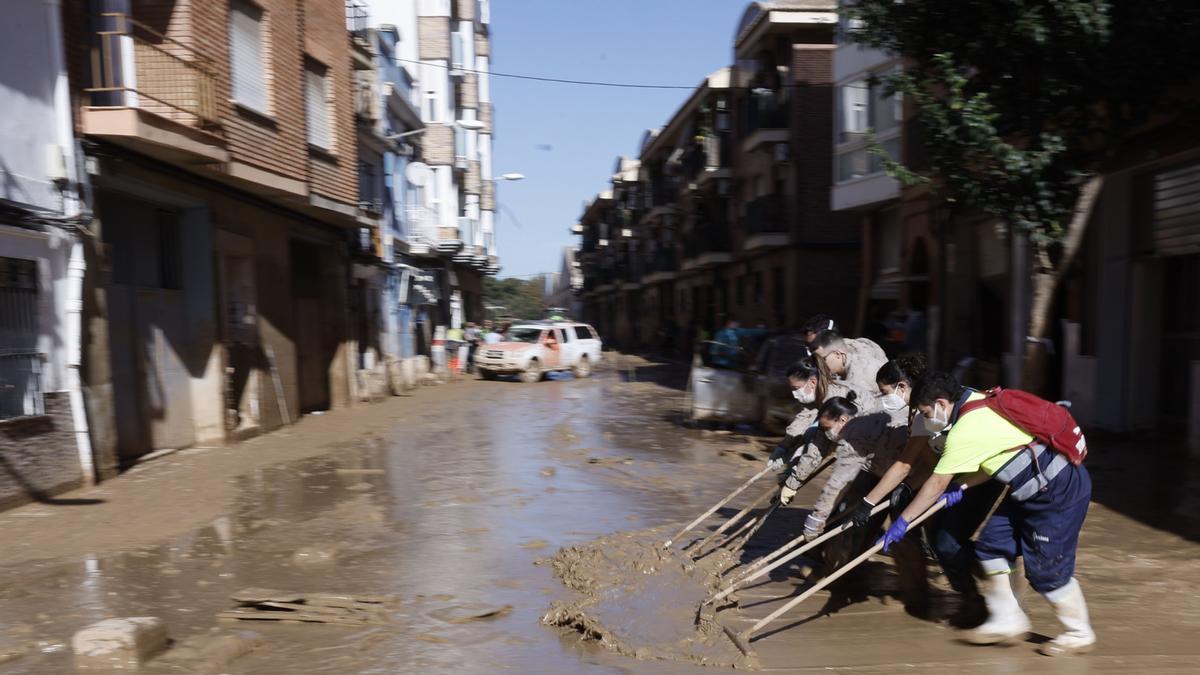 Varias personas trabajan en las labores de limpieza y retirada del lodo de las calles de Paiporta (Valencia) este lunes.