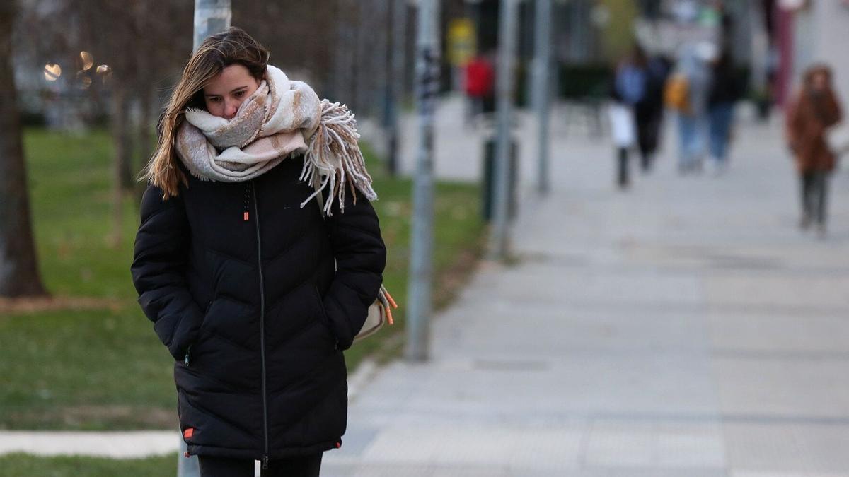 Una mujer se protege del frío en Pamplona.