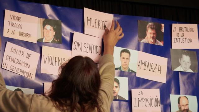 Una persona pone un cartel durante el acto 'El final de ETA. Y ahora, ¿qué? Duelo y perdón'.