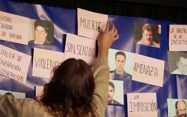 Una persona pone un cartel durante el acto 'El final de ETA. Y ahora, ¿qué? Duelo y perdón'.