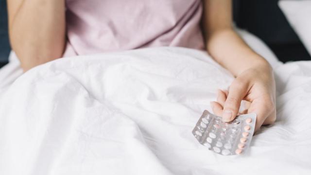 Una mujer sujeta un blister con unas píldoras anticonceptivas.