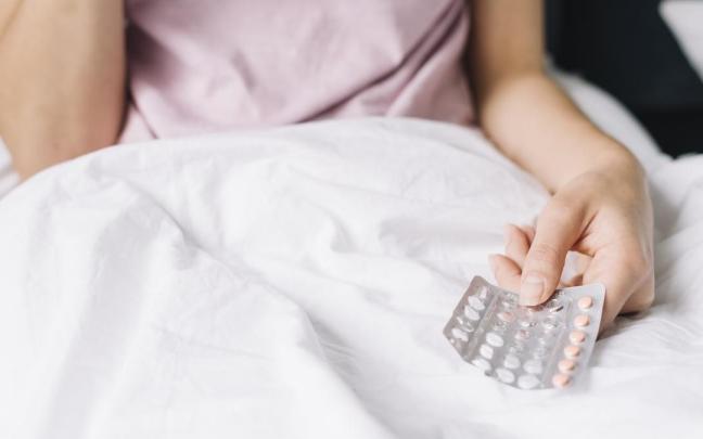 Una mujer sujeta un blister con unas píldoras anticonceptivas.