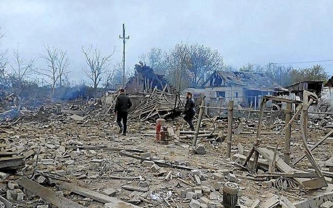 Dos hombres caminan entre los escombros del distrito de Pavlohrad, atacado por los misiles rusos. | FOTO: EFE