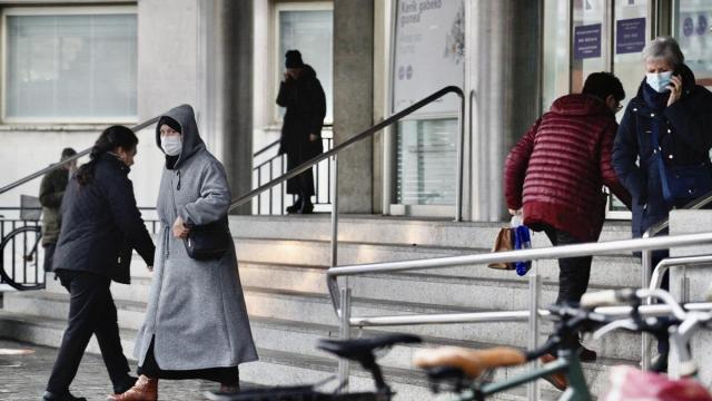 Varias mujeres, algunas de ellas con mascarilla, en la entrada principal del HUA-Txagorrixu. Pilar Barco
