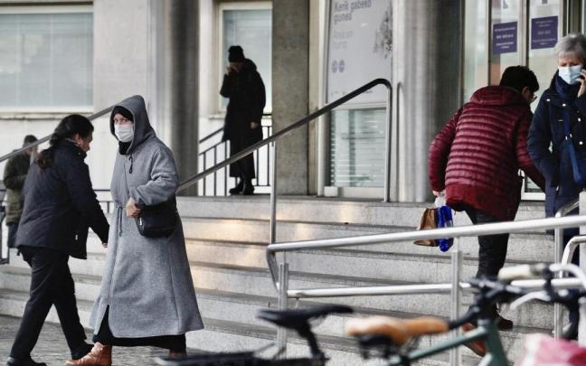 Varias mujeres, algunas de ellas con mascarilla, en la entrada principal del HUA-Txagorrixu. Pilar Barco
