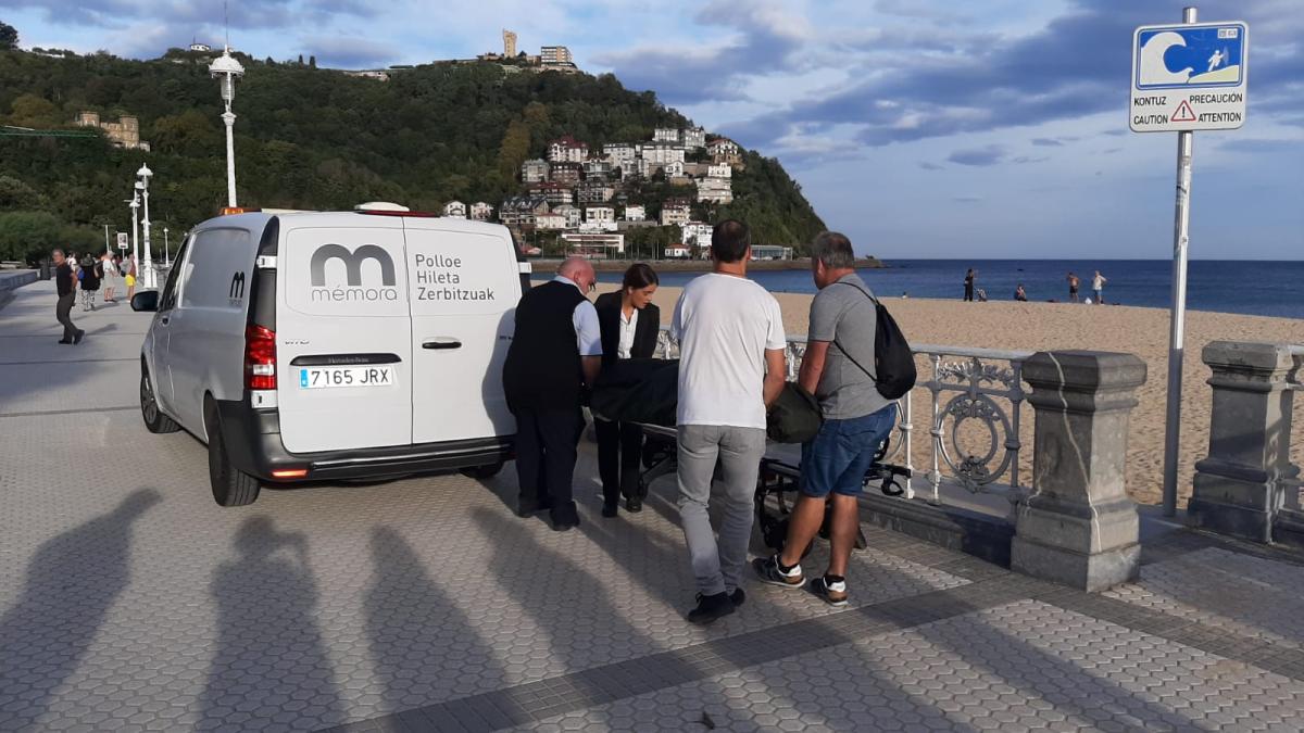 Los servicios funerarios retiran el cuerpo sin vida hallado en la Playa de Ondarreta / ESTHER FERNÁNDEZ