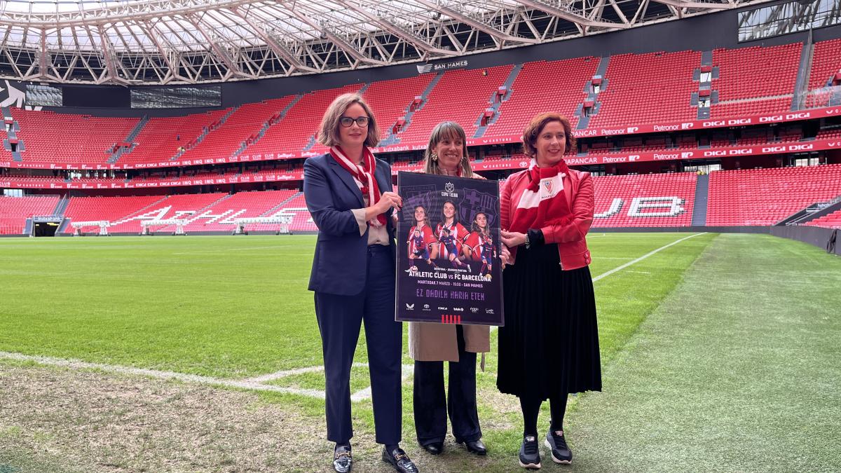 Elixabete Etxanobe, Nerea Ortiz y Amaia Arregi posan con el cartel de presentación del partido del Athletic