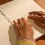 Manos leen Braille.