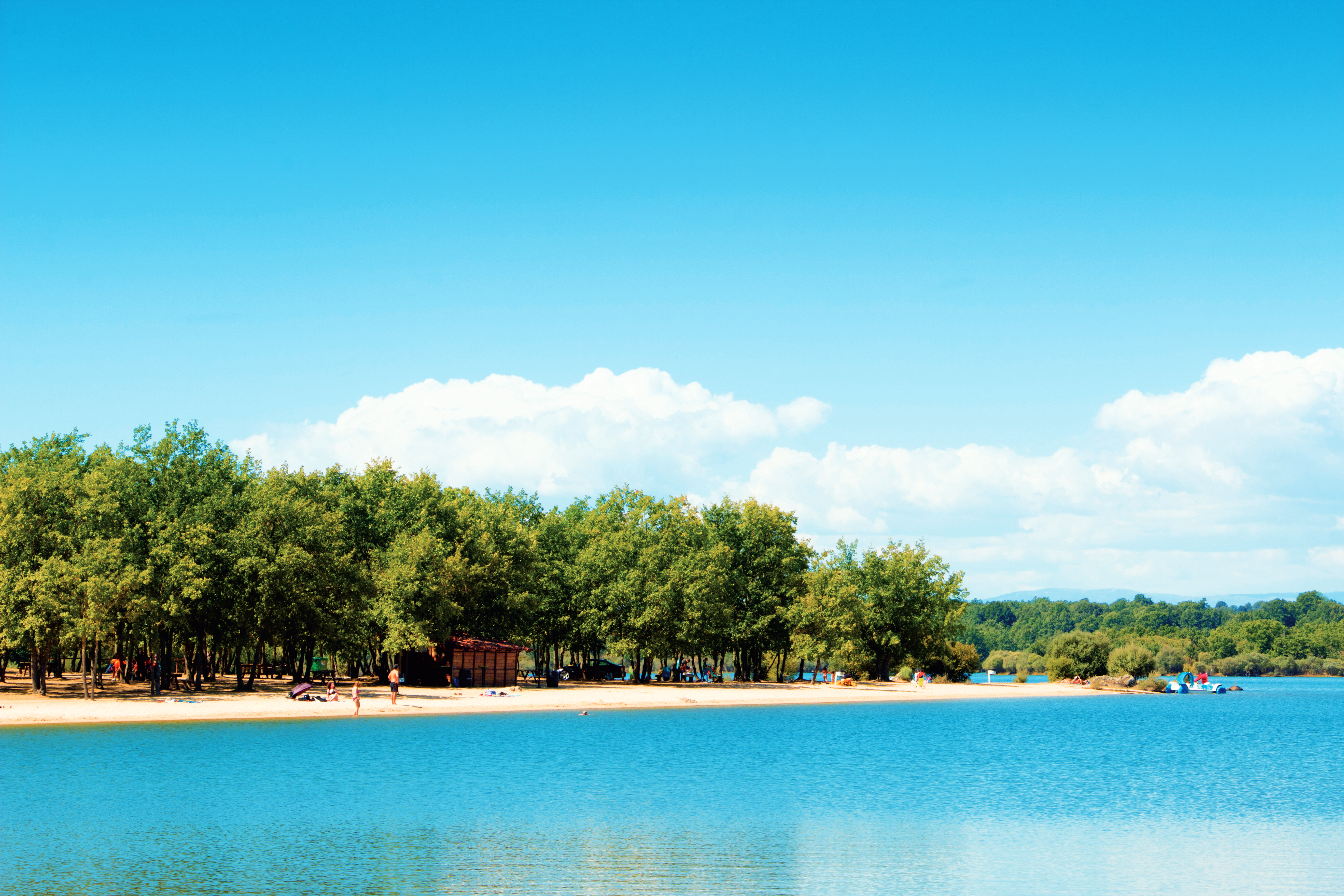 Un amplio arenal en el embalse de Valparaíso, ideal para disfrutar del sol y actividades acuáticas como el paddle surf o paseos en barca de pedales