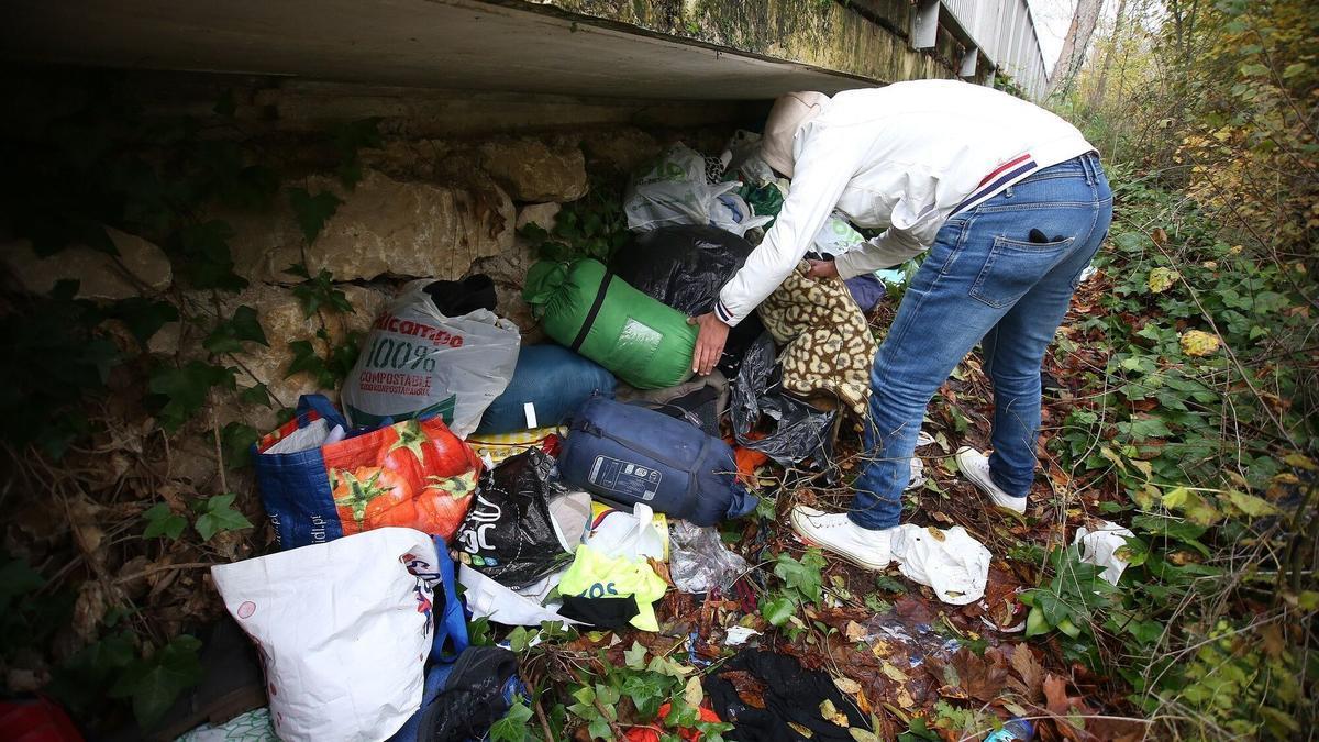 Una persona organiza sus pertenencias en un asentamiento al aire libre. JAVIER BERGASA