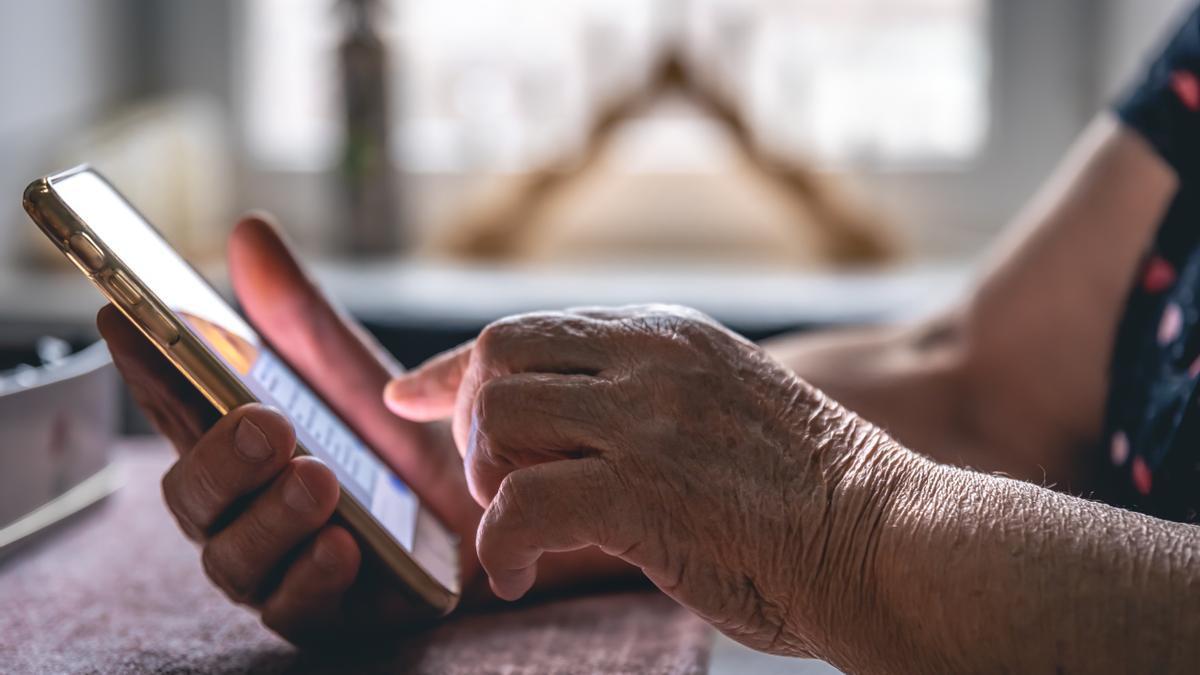 Una mujer mayor usando el móvil. Freepik