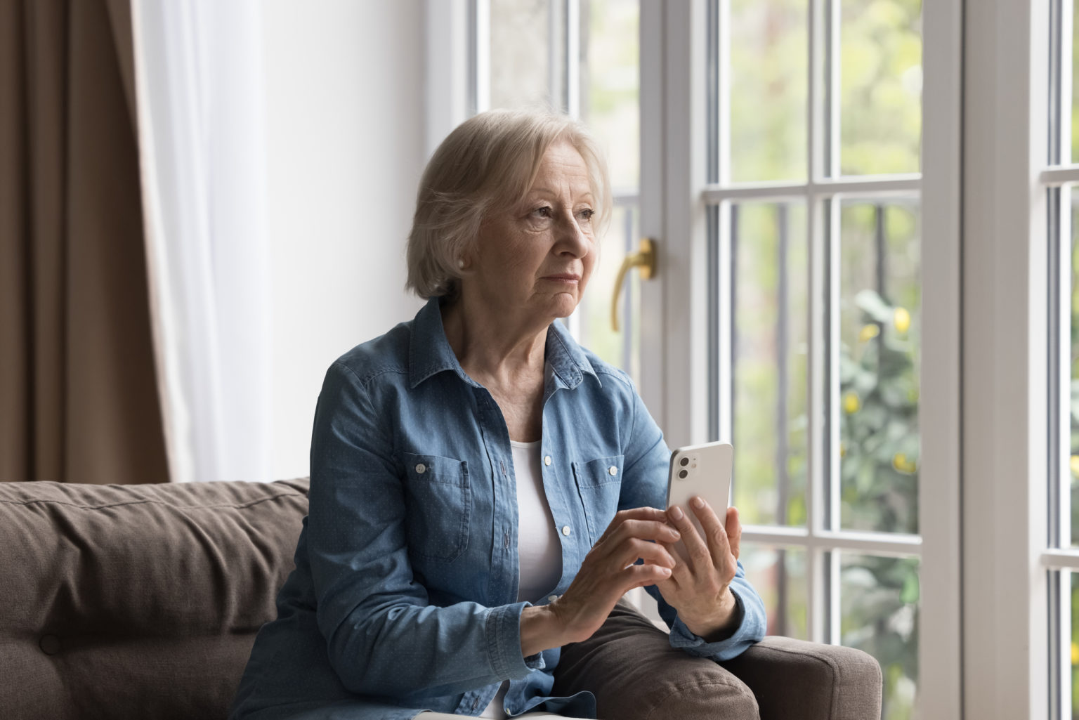 Mujer mayor con un teléfono inteligente en la mano