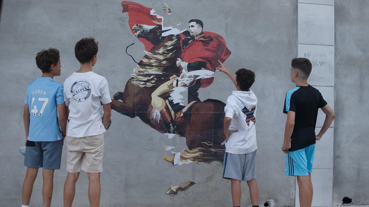 Varios jóvenes, mirando el mural. Patxi Cascante