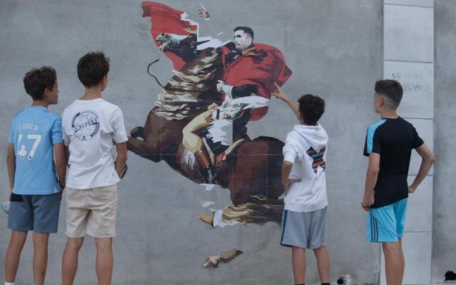 Varios jóvenes, mirando el mural. Patxi Cascante