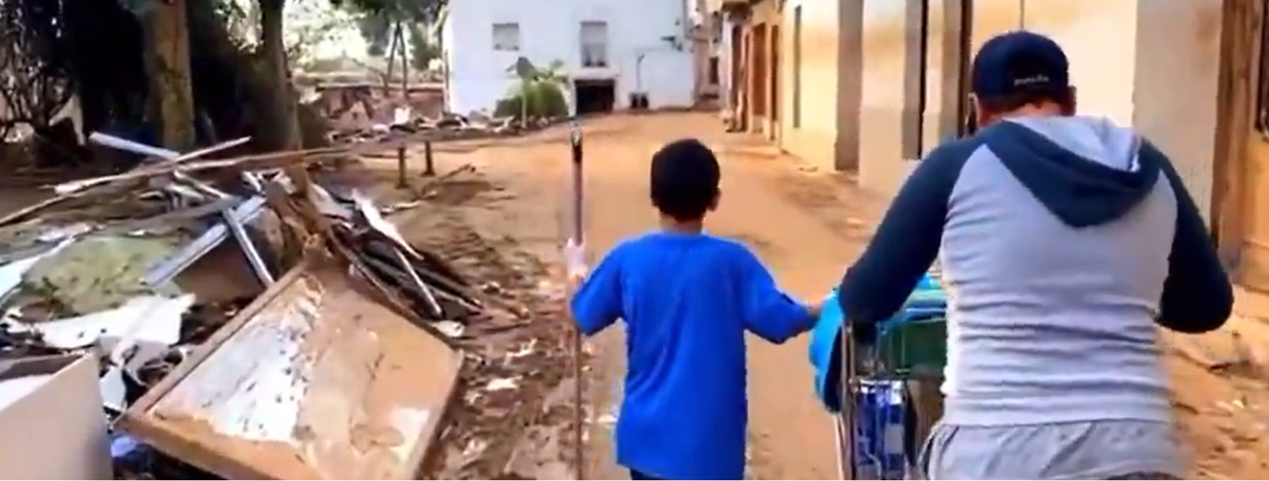 Dos niños reparten comida y enseres en Valencia. X