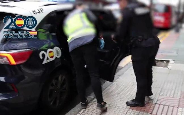 Agentes de la Policía Nacional introducen en un coche policial a un detenido acusado de explotación sexual P.N.