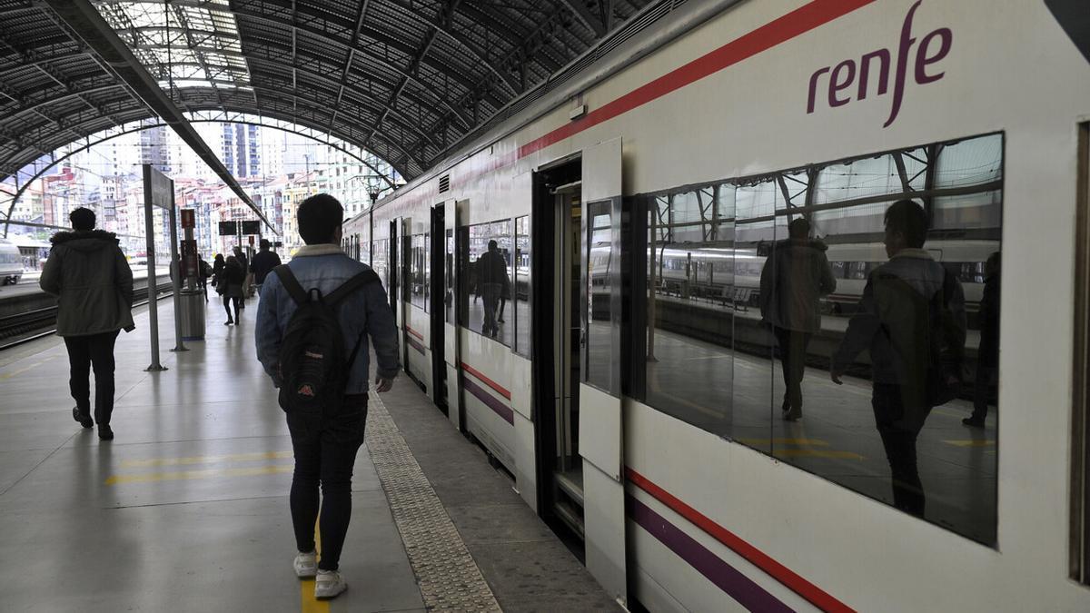 Varios usuarios junto a un tren de Cercanías Renfe en la estación de Abando de Bilbao Oskar González