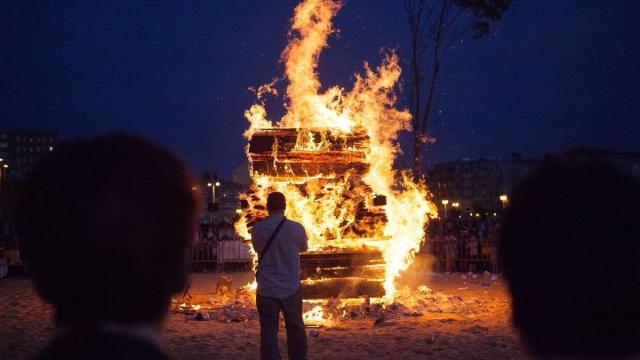 Una persona contempla una hoguera de San Juan. Imagen de archivo.