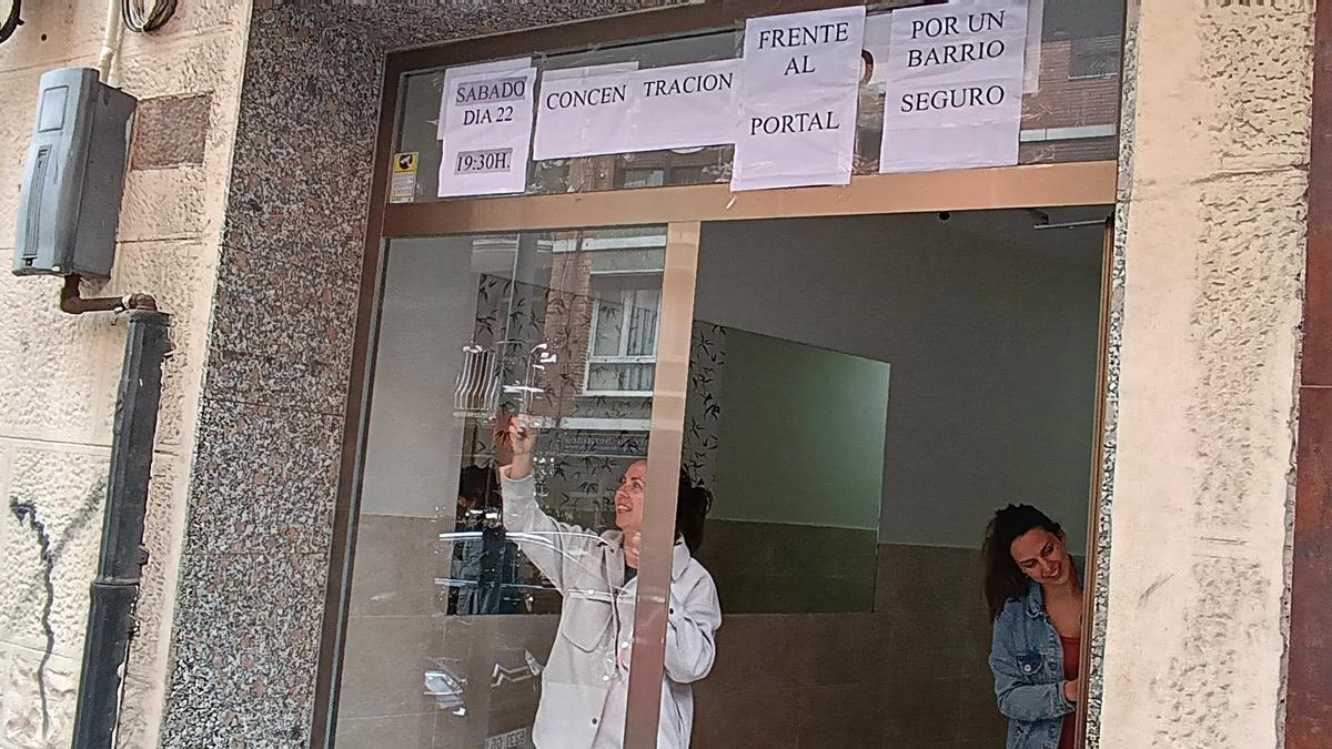 Dos vecinas retiran ayer sonrientes los carteles del portal 13 que protestaban por la presencia de los tres okupas. M. A. PARDO. DEIA.