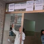 Dos vecinas retiran ayer sonrientes los carteles del portal 13 que protestaban por la presencia de los tres okupas. M. A. PARDO. DEIA.