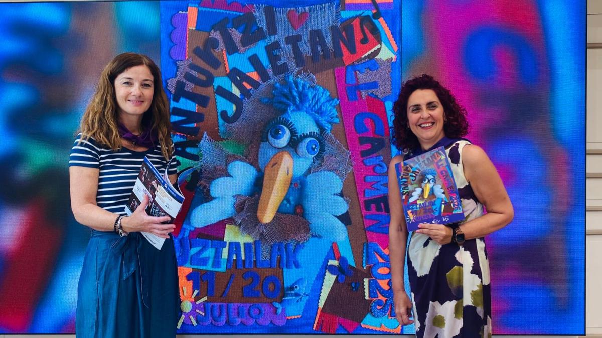 Itziar Carrocera, concejal de Cultura y Euskera, y Karmele Tubilla, alcaldesa, posan junto al cartel de las fiestas de El Carmen de este año en Santurtzi