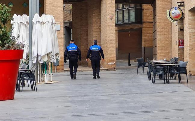 Agentes de la Policía Municipal, de espaldas, patrullando por Tudela. Fermín Pérez Nievas