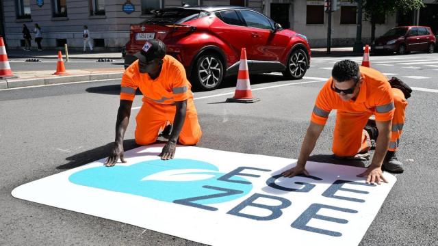 Dos operarios instalando una señal de la ZBE en el acceso a la Gran Vía desde la plaza del Sagrado Corazón. OSKAR GONZÁLEZ